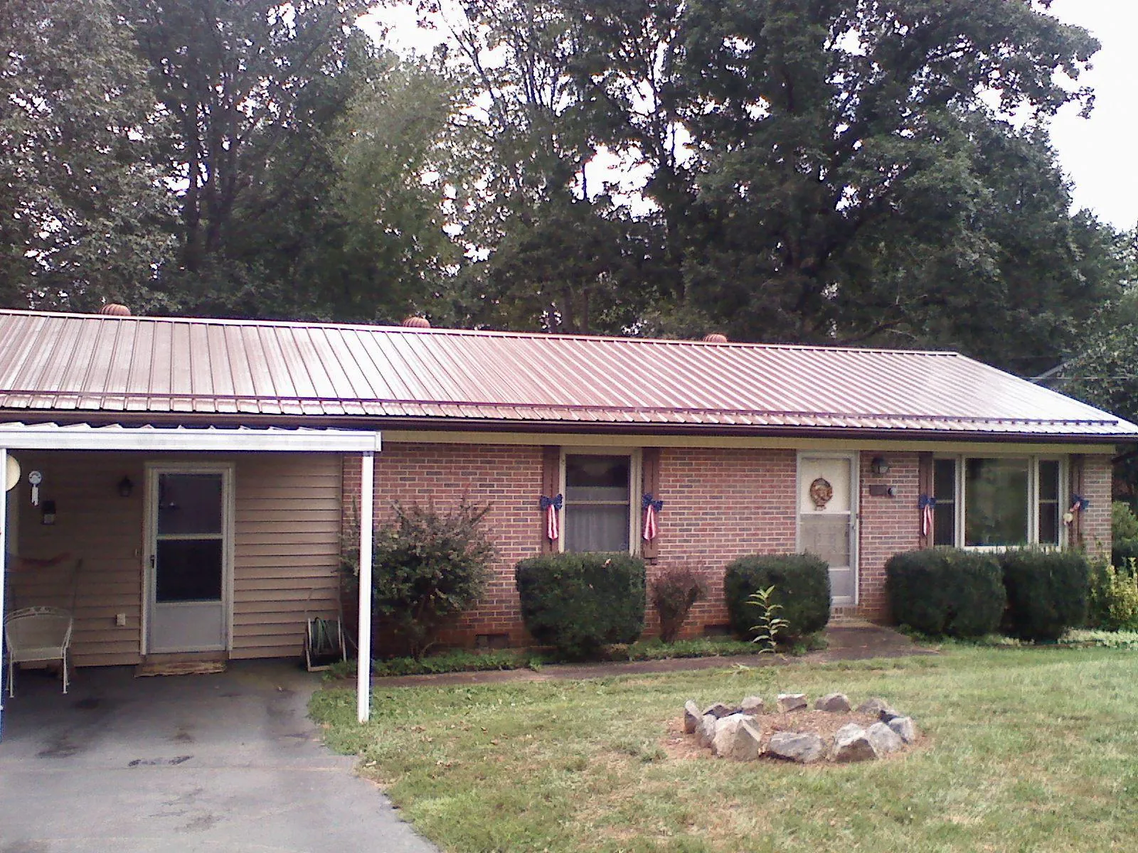 Bronze metal roof and carport on a brick ranch home in Sand Springs