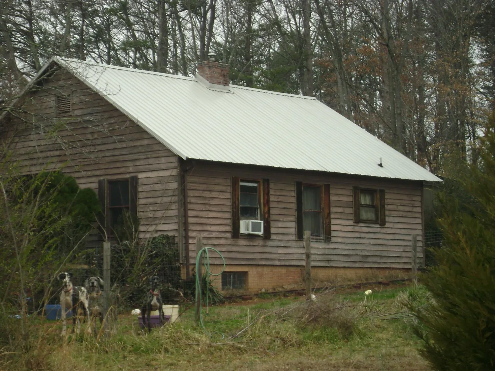 White metal roof on an old wood sided farmhouse, from a Metal Roof Installation job in Sand Springs
